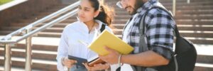 Law school students standing outside of a building, holding books